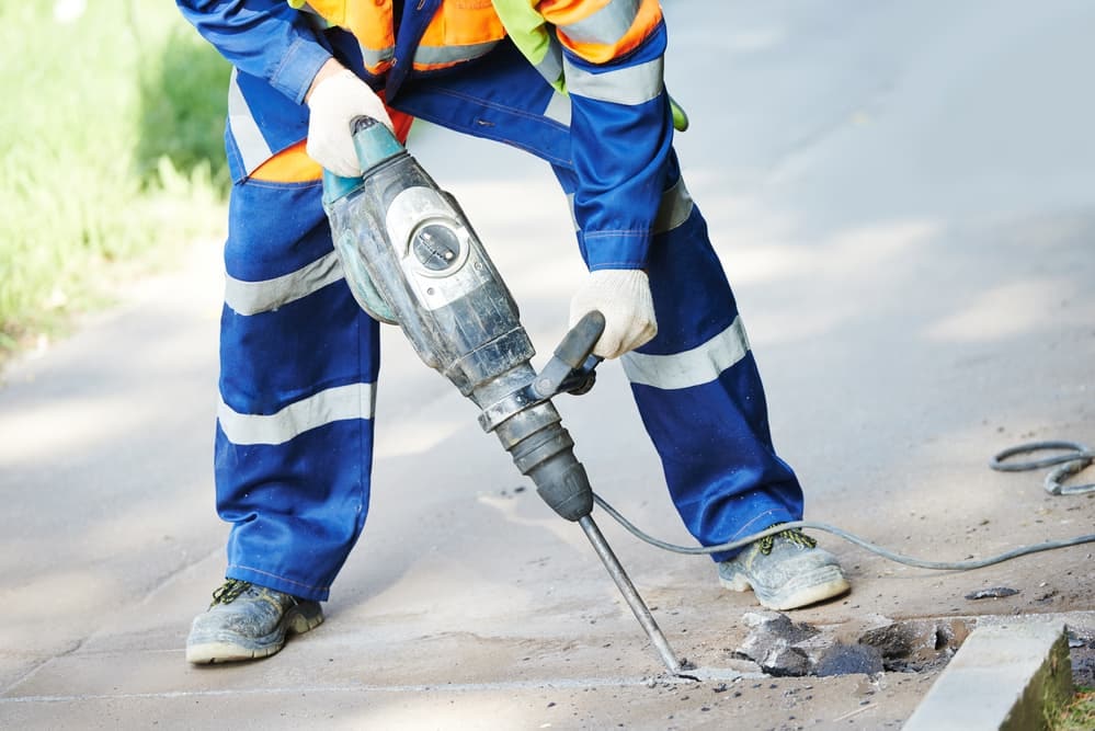 roadworker with jackhammer and vibration monitoring tool