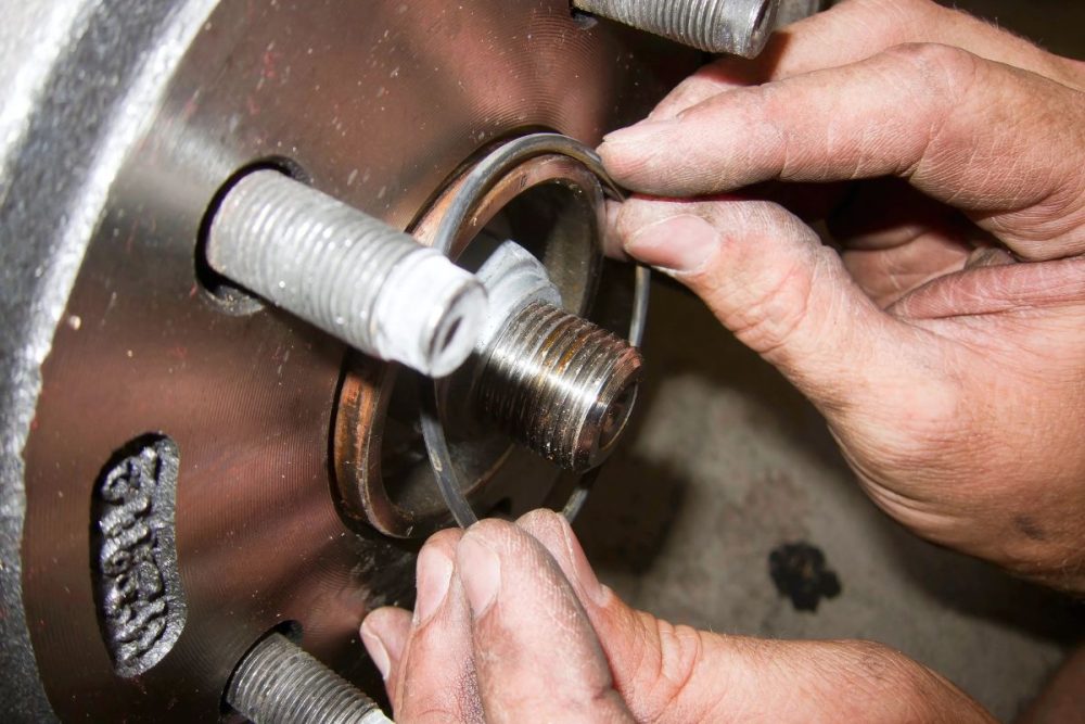 A mechanic's hand installing an o-ring.