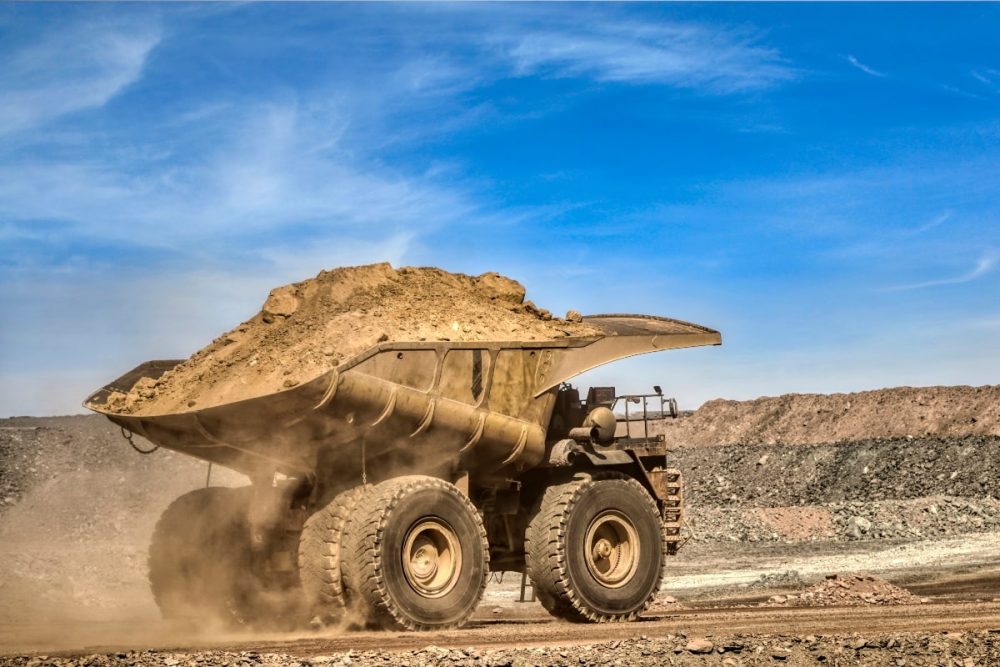 Loaded mining vehicle in rugged terrain.