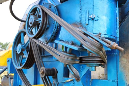 Close-up of a V-belt system on blue combine harvester.